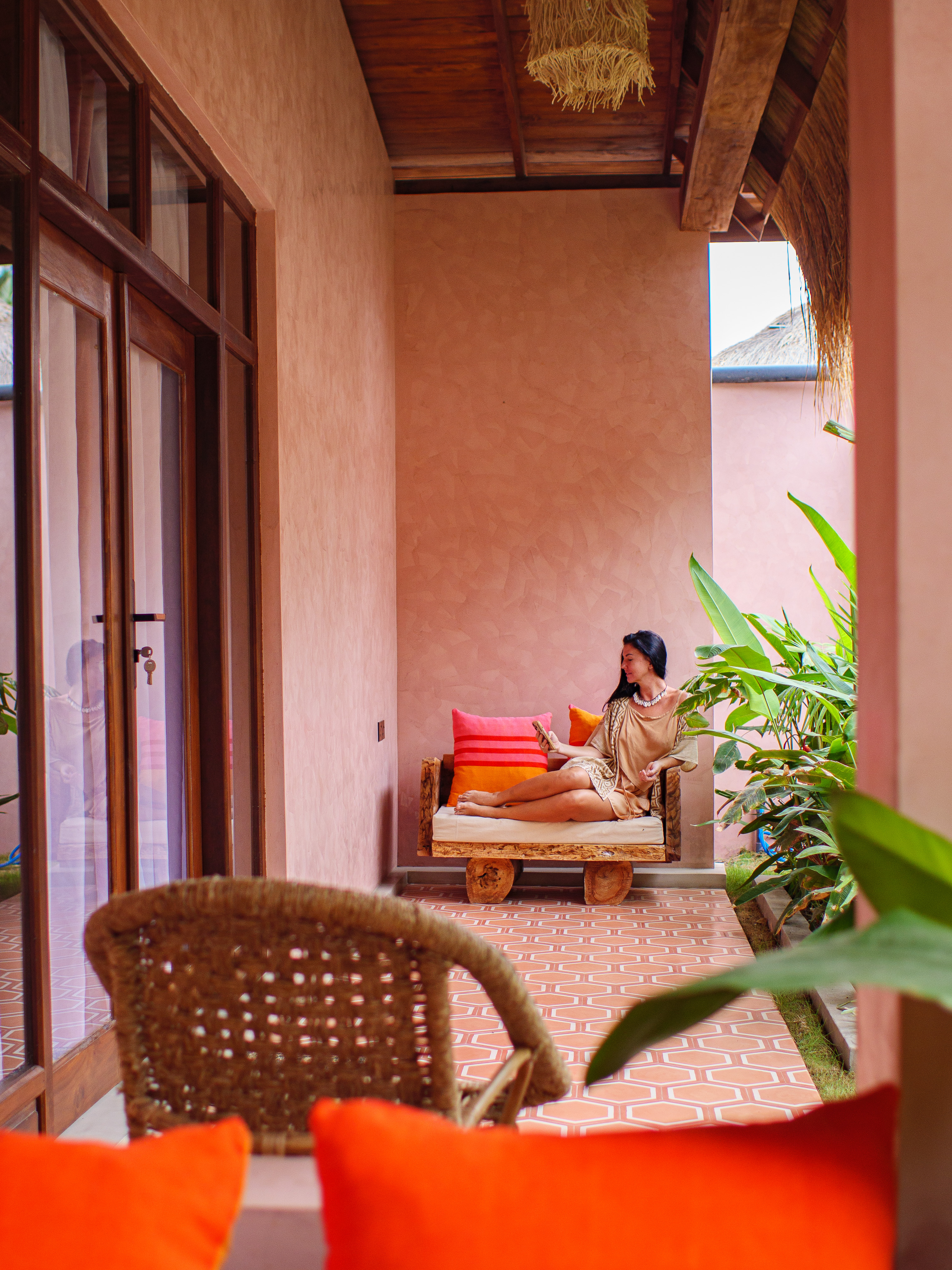 Woman relaxing on a private terrace with tropical garden views outside a double room at Pine and Palm in Arugam Bay